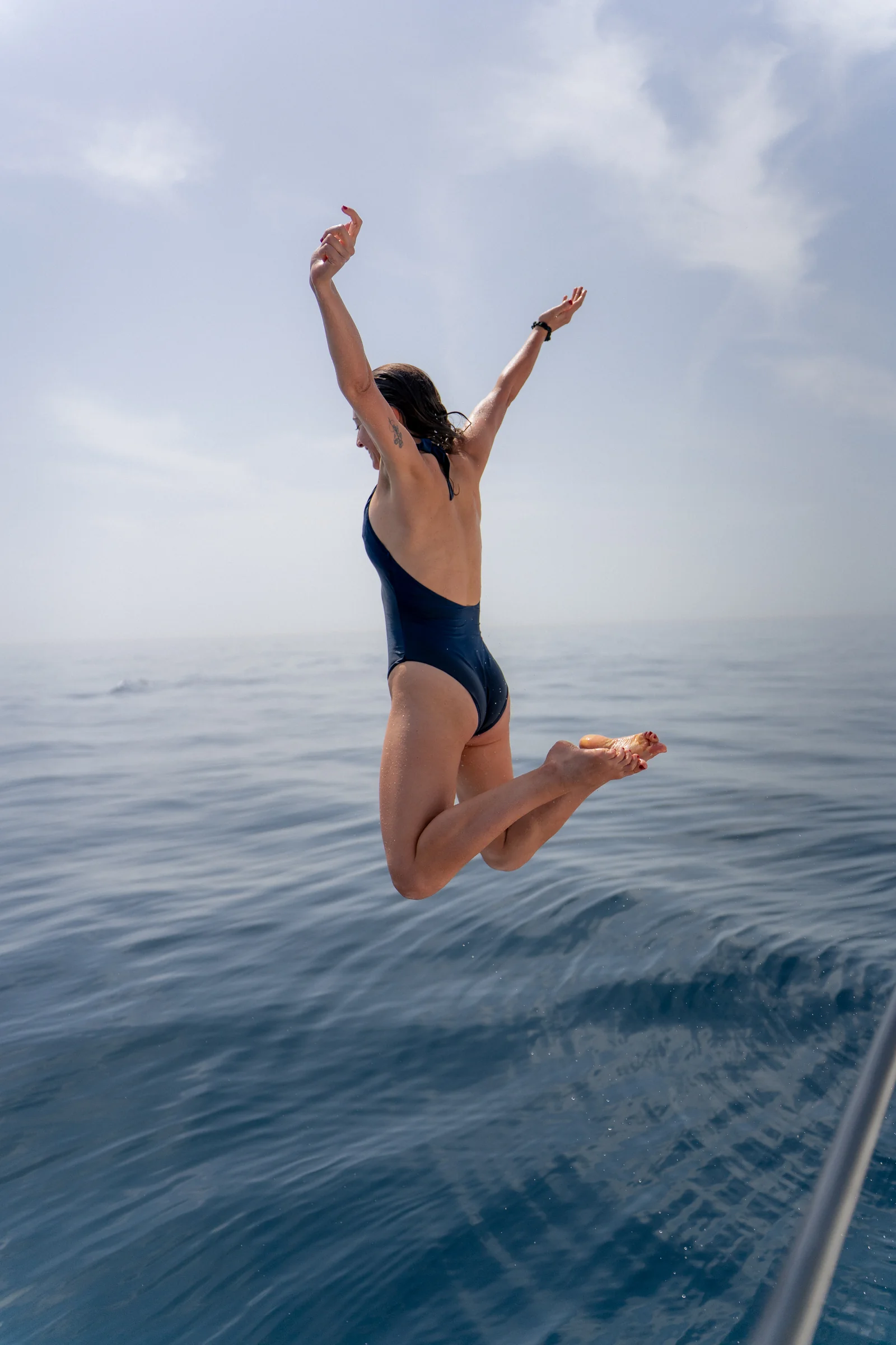 Una persona salta al agua desde el catamarán.