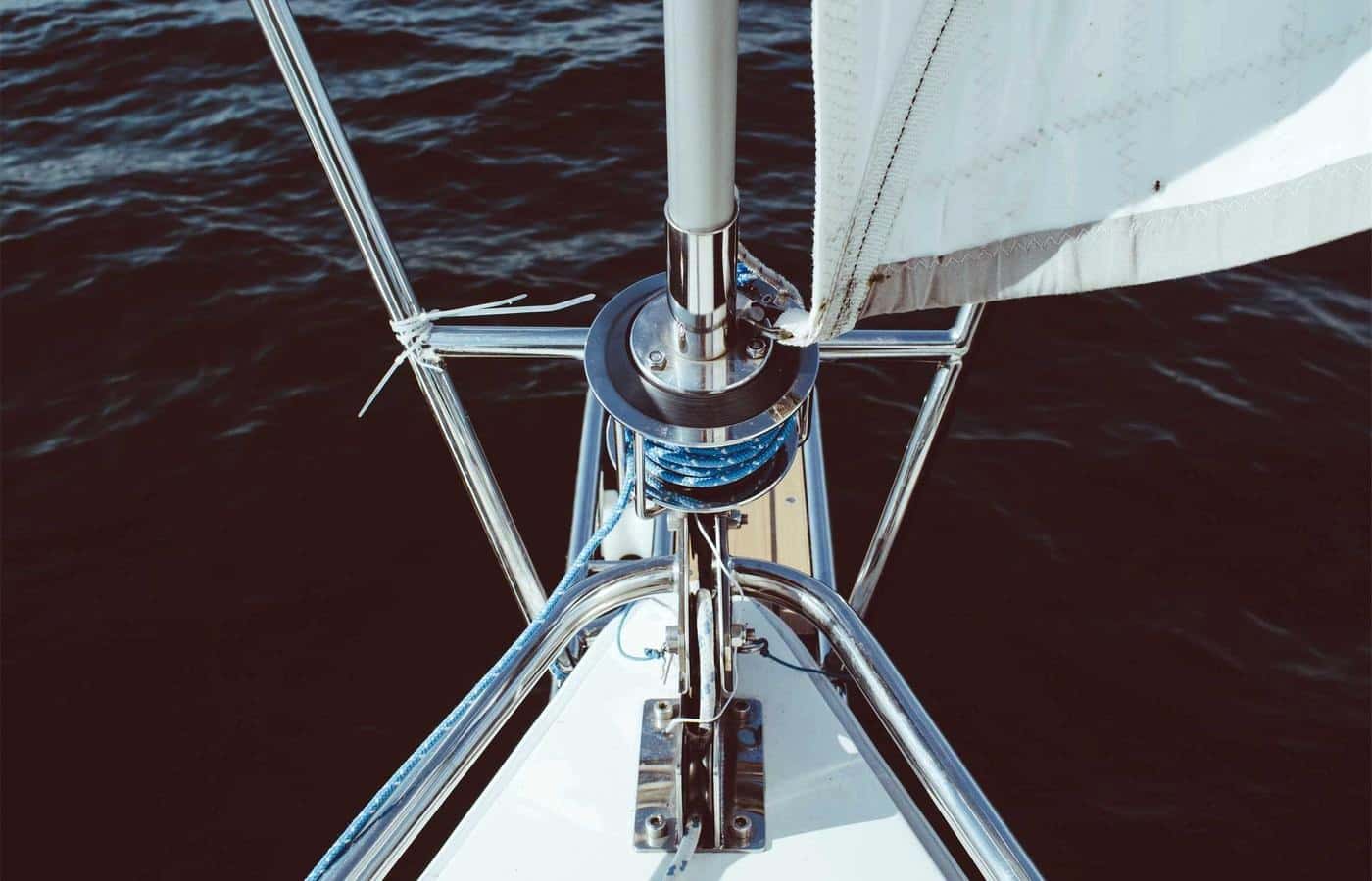 Proa de un velero navegando con la vela desplegada.