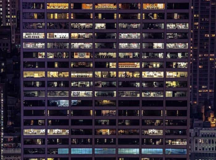 Fachada de un edificio de oficinas iluminada de noche.